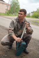 Глава администрации Залесовского района Андрей Ермоленко настраивает мотопилу для работы